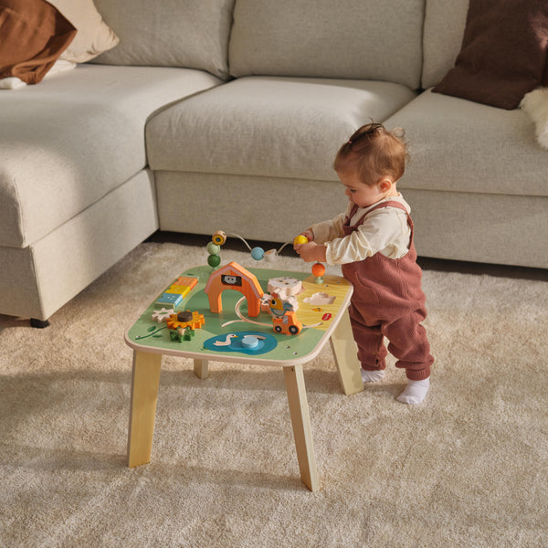 Bebê a brincar com mesa de atividades Tiny Love