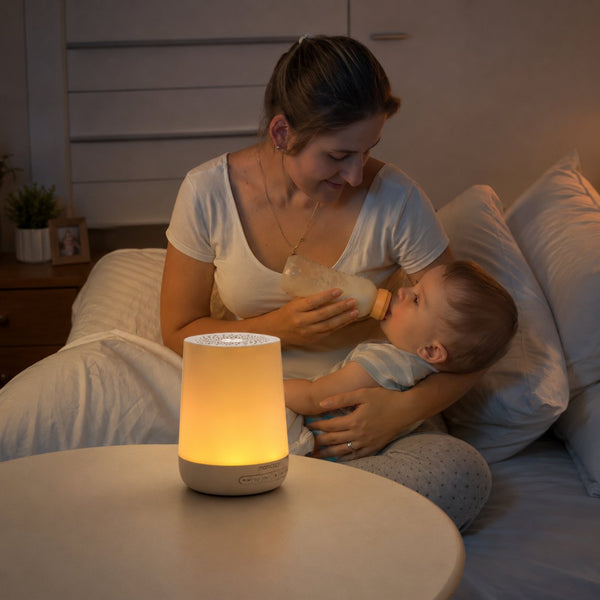Máquina de Ruído Branco e Luz de Presença Momcozy com 20 sons relaxantes, luz regulável, temporizador e design portátil para ajudar o bebé a dormir melhor.