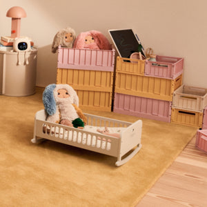 Cama de Bonecas Hennie em madeira com função de baloiço, indicada para bonecas e peluches e para brincadeiras de faz de conta.