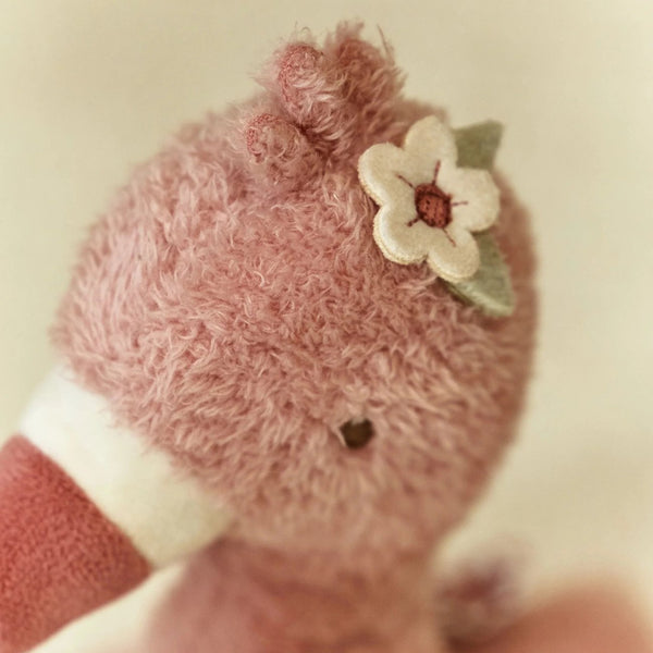 Peluche Flamingo 35 cm em tecido macio com diferentes texturas e flor interativa, ideal para estimular os sentidos e proporcionar conforto ao bebé.