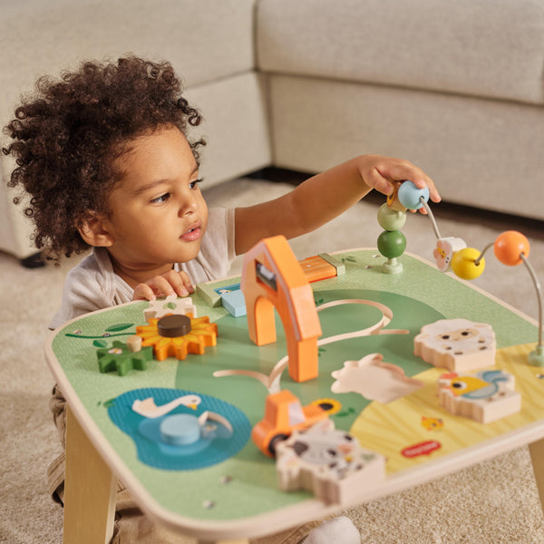 Bebê a brincar com mesa de atividade tiny love