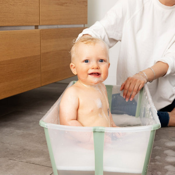 Conjunto Stokke® Flexi Bath® com banheira dobrável, suporte para recém-nascido e suporte para banheira, ideal para um banho confortável e seguro desde o nascimento. Transparent Green